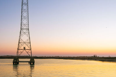 Scenic view of electricity pylon against sky during sunset