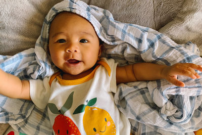 Portrait of cute baby boy lying on bed