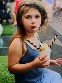Side view portrait of girl eating ice cream in city