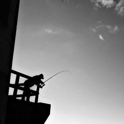 Low angle view of man with fishing pole