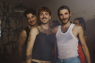 Portrait of smiling gay men standing together at nightclub