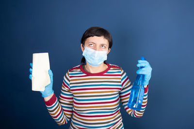 Portrait of man standing against blue background