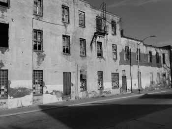 Street by buildings in city against sky