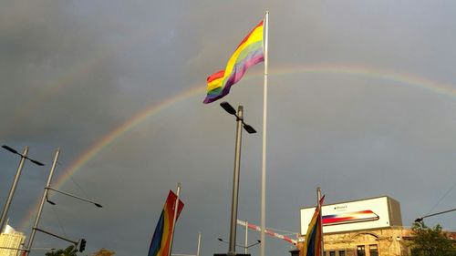 Multi colored flags on rainbow against sky