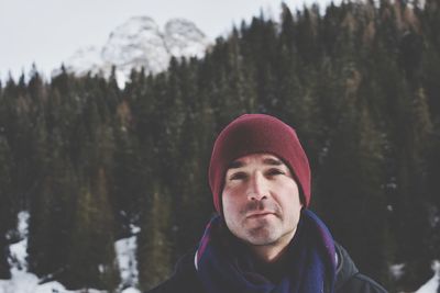 Portrait of man in snow against trees during winter
