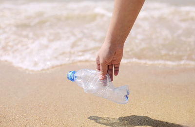 Woman holding bottle on beach