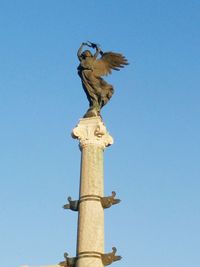 Low angle view of statue against clear blue sky