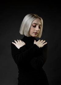 Portrait of a beautiful young woman over black background