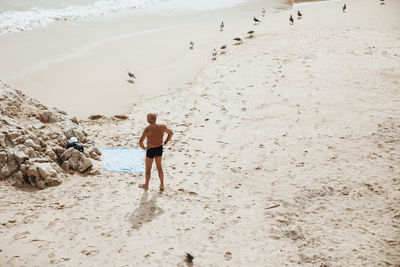 Rear view of man walking on beach