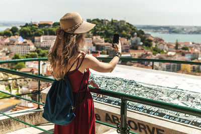 Rear view of woman standing against city