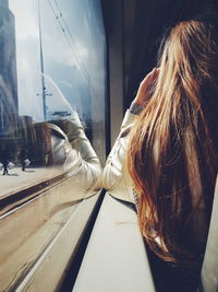 Rear view of woman sitting in train