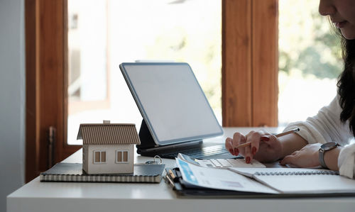 Midsection of woman using laptop on table