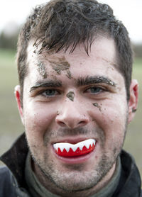 Close-up portrait of a young man with fake teeth