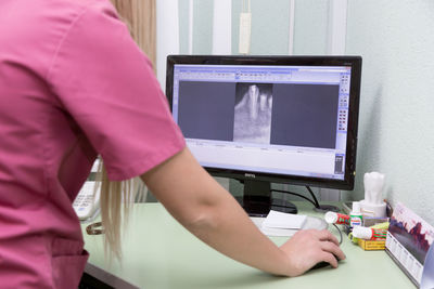 Midsection of man using mobile phone on table