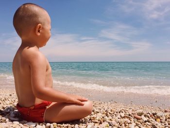 Boy on beach against blue sky