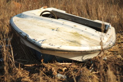 Abandoned boat moored on field