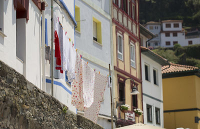 Low angle view of clothes hanging against residential buildings