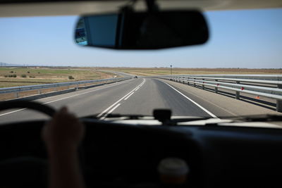 Blurred motion of car moving on road seen through windshield