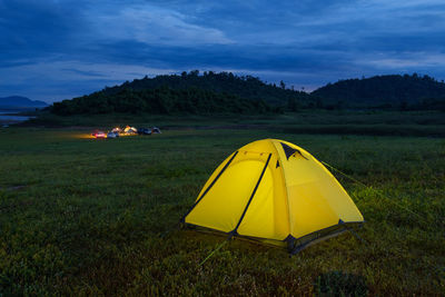 Yellow tent on field against sky