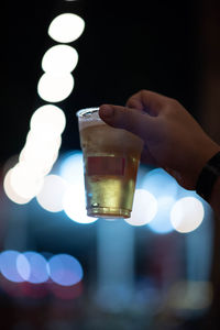 Midsection of person holding beer glass