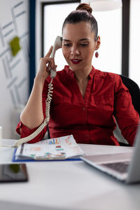 Businesswoman talking on phone at office