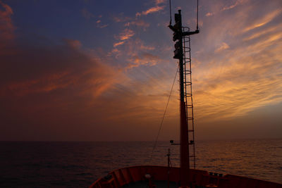 Silhouette sailboat on sea against sky during sunset