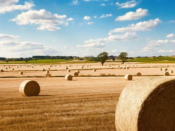 Hay bales on field against sky