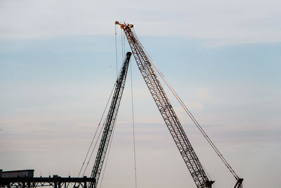 Low angle view of crane against sky