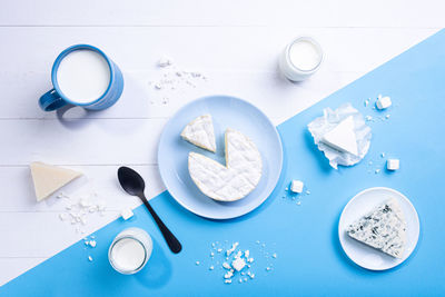 Flat lay composition with dairy products in white and blue background.