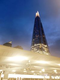 Low angle view of illuminated buildings against sky in city