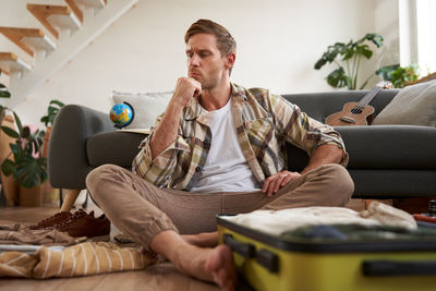 Young woman using mobile phone while sitting at home