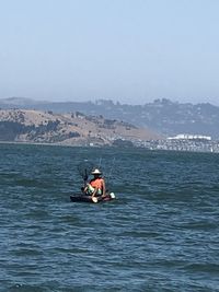 People on boat in sea against sky