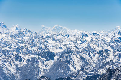 Scenic view of snowcapped mountains against clear blue sky