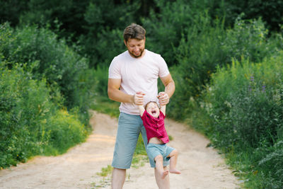 Happy dad having fun with his little son, shaking his hands from side to side person