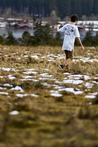 Rear view of boy walking on field