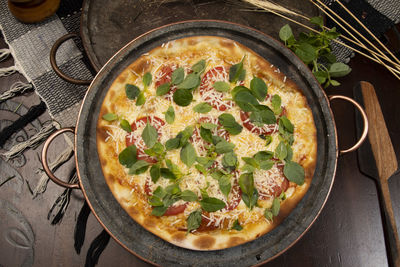 Brazilian pizza with pepperoni, cheese  arugula, top view