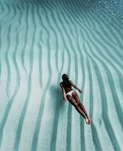 High angle view of woman relaxing on sand