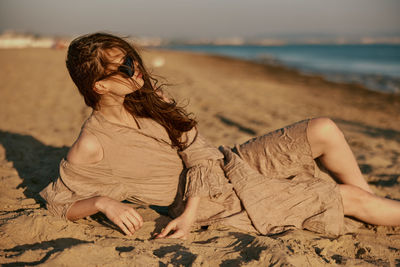 Young woman sitting at beach