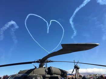 Low angle view of vapor trail against blue sky