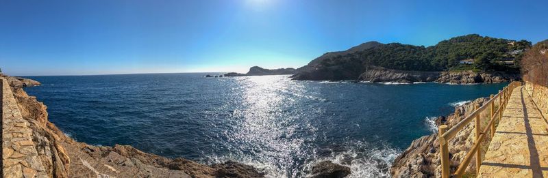 Panoramic view of sea against clear blue sky