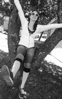 Woman standing on tree trunk