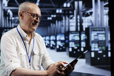 Side view of man using mobile phone in office