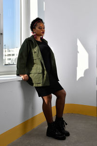 A pretty young african american confident woman in the stairwell of an old apartment building.