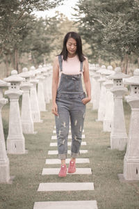 Portrait of young woman walking on footpath