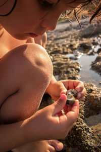 Close-up of girl with seashells at beach