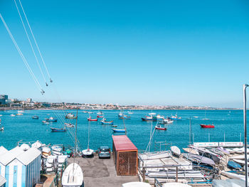 Sailboats moored on sea against clear blue sky