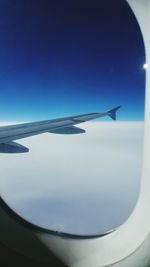 Cropped image of airplane against blue sky