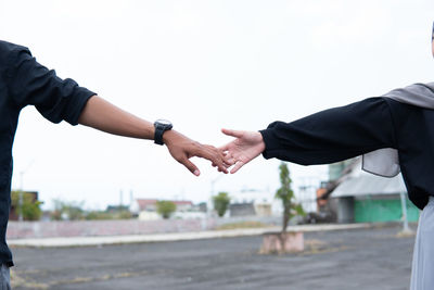 Low section of man holding hands