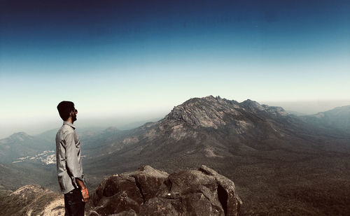 Man looking at mountain range against sky