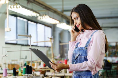 Full length of young woman using mobile phone